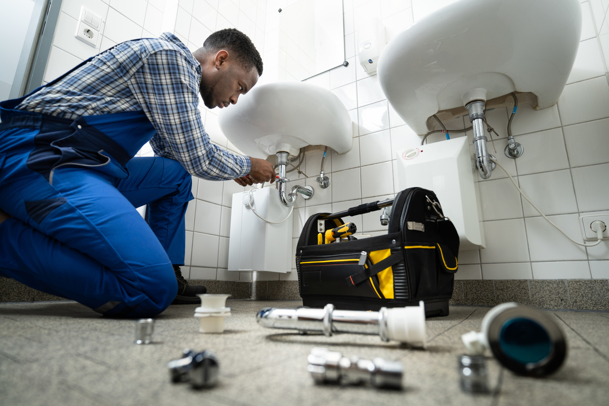 Our Services plumber fixing pipe in bathroom. plumbing maintenance